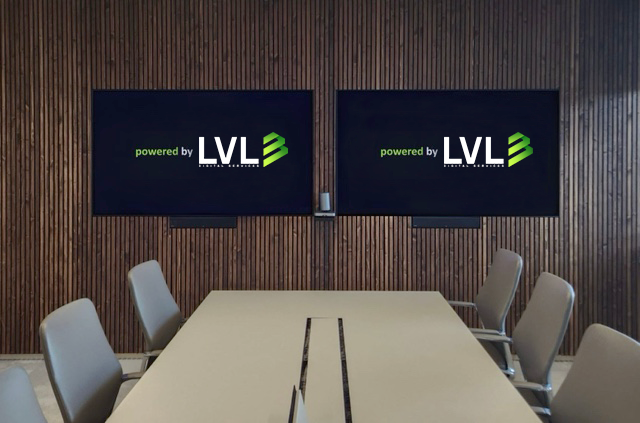 Ein Konferenzraum mit einem langen Tisch, Stühlen und zwei Bildschirmen an der Wand, die das Logo "powered by LVL" anzeigen.